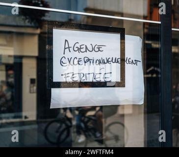 Eine Mitteilung in französischer Sprache an der Glastür, die die Schließung einer Agentur vorsieht Stockfoto