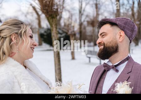 Augsburg, Bayern, Deutschland - 19. Januar 2024: Junge Braut und Bräutigam schauen sich bei ihrer Hochzeit verliebt in die Augen *** Junges Brautpaar schaut sich bei der Hochzeit verliebt in die Augen Stockfoto