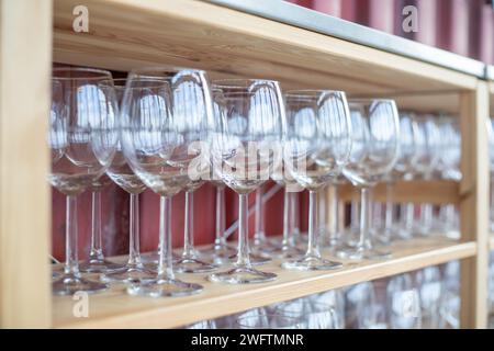 Viele leere und saubere Weingläser auf Holzregalen Stockfoto