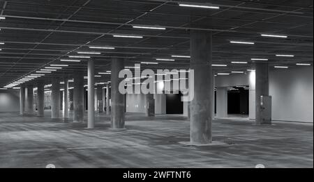 Abstraktes leeres Industrieinnere mit Betonsäulen und Neonlichtern, Hintergrundfoto moderner Architektur Stockfoto