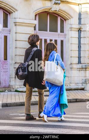 Rückansicht des schicken Paares - Frau in himmelblauem Mantel - über die Straße der Stadt - Tours, Indre-et-Loire (37), Frankreich. Stockfoto