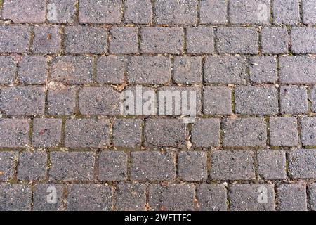 Textur des Gehweges von oben gesehen. Alte unregelmäßige Steine werden verwendet. Stockfoto