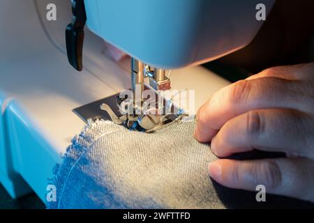 Nahaufnahme der Hände einer Frau, die mit dem eine Hose näht Nähmaschine Stockfoto