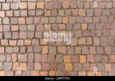 Textur des Gehweges von oben gesehen. Alte unregelmäßige Steine werden verwendet. Stockfoto