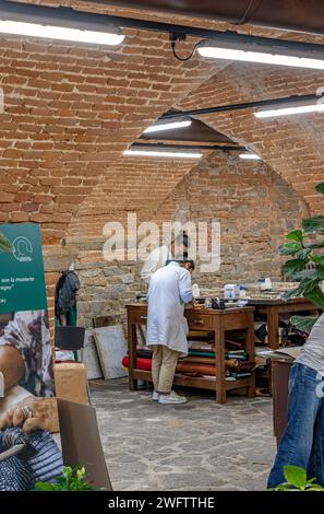 Erfahrene Lederarbeiter, die Lederwaren im Florence Schhool of Leather, Scuola del Cuoio, Florenz, Italien herstellen Stockfoto