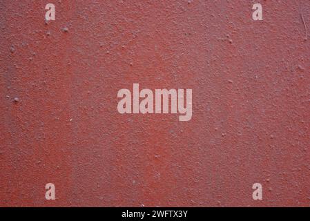 Eine alte, unebene Metalloberfläche mit Unebenheiten, die mit brauner, roter Kirschfarbe bedeckt sind. Rauer brauner, metallischer Hintergrund. Stockfoto