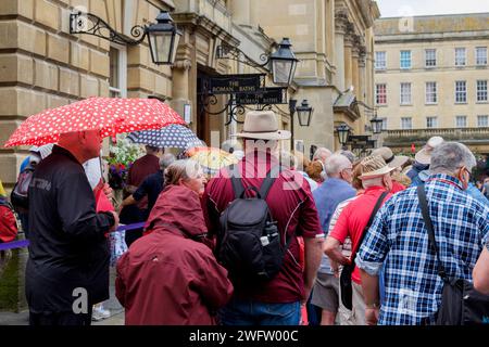 Touristen werden in der Warteschlange vor den weltberühmten Pumpenräumen in Bath zu sehen sein. Stockfoto