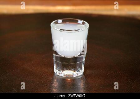 Ouzo oder Raki - traditioneller balkananis starkes alkoholisches Getränk auf dem Tisch in Nahaufnahme. Stockfoto