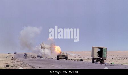 Erster Golfkrieg: 4. März 1991 ein verlassener irakischer T55-Panzer spuckt Rauch und Flammen aus, während er auf der Route 801, der Straße nach um Qasr, nördlich von Kuwait City, brennt. Stockfoto