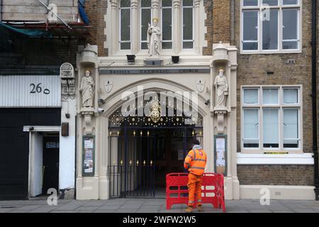 Arbeiter vor dem Eingang der Servite Catholic Church (Our Lady of Dolours) Chelsea London England Stockfoto