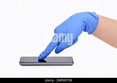 Zugeschnittene Aufnahme einer nicht erkennbaren Frauenhand mit Latexhandschuh, die mit Zeigefinger auf einem weißen, isolierten Hintergrund einen Handy-Bildschirm berührt Stockfoto