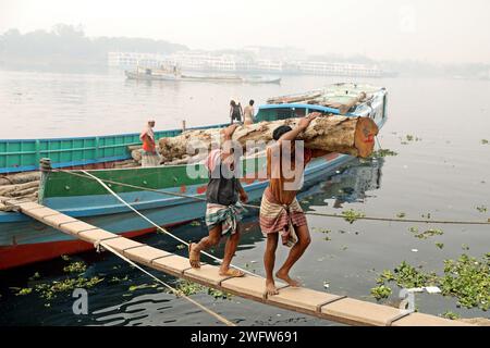 Dhaka, Wari, Bangladesch. Februar 2024. Arbeiter sortieren Holzscheite, die am 1. Februar 2024 von einem Boot am Ufer des Buriganga River in Dhaka entladen wurden. (Kreditbild: © Habibur Rahman/ZUMA Press Wire) NUR REDAKTIONELLE VERWENDUNG! Nicht für kommerzielle ZWECKE! Stockfoto