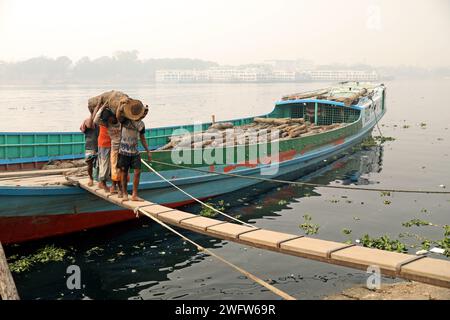 Dhaka, Wari, Bangladesch. Februar 2024. Arbeiter sortieren Holzscheite, die am 1. Februar 2024 von einem Boot am Ufer des Buriganga River in Dhaka entladen wurden. (Kreditbild: © Habibur Rahman/ZUMA Press Wire) NUR REDAKTIONELLE VERWENDUNG! Nicht für kommerzielle ZWECKE! Stockfoto