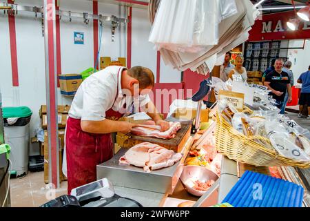 Ein Metzger, der einen Fleischschnitt im Florence Mercato Centrale zubereitet, einem beliebten Markt für frische Lebensmittel und Produkte in Florenz, Italien Stockfoto