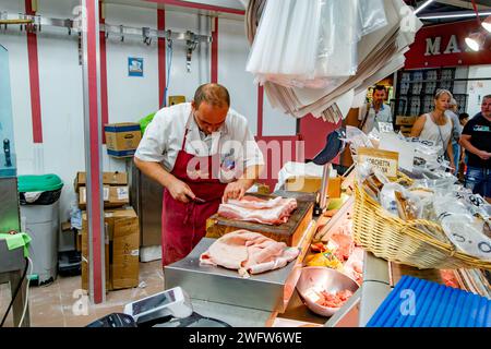 Ein Metzger, der einen Fleischschnitt im Florence Mercato Centrale zubereitet, einem beliebten Markt für frische Lebensmittel und Produkte in Florenz, Italien Stockfoto