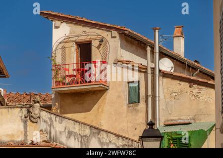 Ein kleines Apartment mit einem Balkon aus rotem Schmiedeeisen mit einem kleinen Tisch und Stühlen in Florenz, Italien Stockfoto