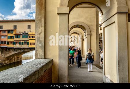 Menschen gehen durch den Vasari Corrider, der parallel zum Fluss Arno verläuft, von den Uffizien zur Brücke Ponte Vecchio in Florenz, Italien Stockfoto