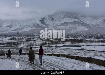 Kaschmir, Indien. Februar 2024. Die Bewohner gehen nach dem Schneefall durch eine schneebedeckte Straße in Ganderbal, etwa 30 km von Srinagar, der Sommerhauptstadt von Jammu und Kaschmir, entfernt. Das Kaschmir-Tal erhielt in den letzten zwei Monaten frischen Schneefall, der die lange Trockenzeit durchbrach. Die Meteorologische Abteilung gab eine Vorhersage des bewölkten Wetters tagsüber heraus, begleitet von der Wahrscheinlichkeit von leichtem bis mäßigem Regen und Schnee an verschiedenen Orten während der nächsten 24 Stunden. (Credit Image: © Saqib Majeed/SOPA Images via ZUMA Press Wire) NUR REDAKTIONELLE VERWENDUNG! Nicht für kommerzielle ZWECKE! Stockfoto