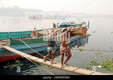 Dhaka, Bangladesch. Februar 2024. Arbeiter sortieren Holzscheite, die am 1. Februar 2024 von einem Boot am Ufer des Buriganga River in Dhaka entladen wurden. Foto: Habibur Rahman/ABACAPRESS.COM Credit: Abaca Press/Alamy Live News Stockfoto