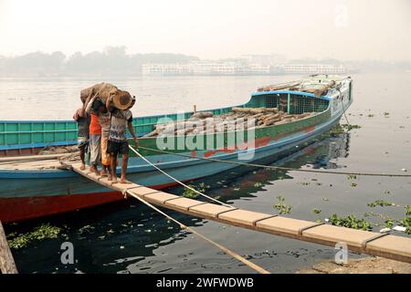 Dhaka, Bangladesch. Februar 2024. Arbeiter sortieren Holzscheite, die am 1. Februar 2024 von einem Boot am Ufer des Buriganga River in Dhaka entladen wurden. Foto: Habibur Rahman/ABACAPRESS.COM Credit: Abaca Press/Alamy Live News Stockfoto