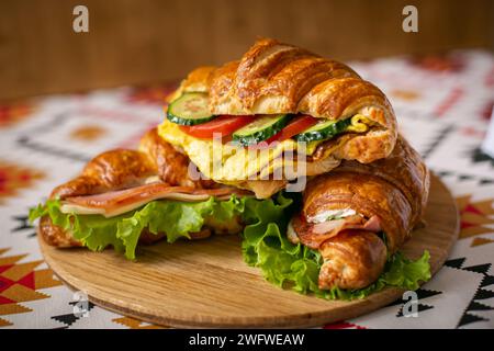 Verschiedene Croissants im Restaurant auf einem Holzteller. Croissant mit Gemüse und Meet Stockfoto