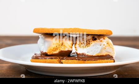 Grahams Cracker mit Marshmallows und Schokolade auf weißem Teller mit Kopierraum Stockfoto