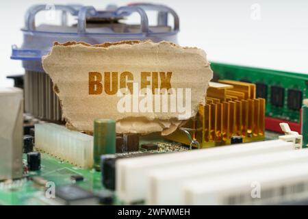 Auf der Hauptplatine des Computers befindet sich eine Pappe mit der Aufschrift Bug Fix. Computerkonzept. Stockfoto