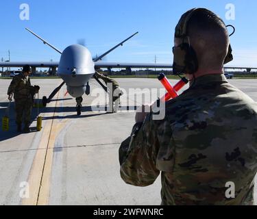 Ein Mitglied der 147th Attack Wing Aircraft Maintenance Squadron schickt am 10. Januar 2024 einen MQ-9 Reaper zum Parken am Scholes International Airport in Galveston, Texas. Der Wing testete die Start- und Bergungsoperationen am internationalen Flughafen Scholes in Galveston als Teil seines innovativen Ansatzes für das Konzept der Agile Combat Employment. Stockfoto