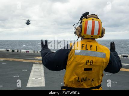 PHILIPPINE SEA (23. Januar 2024) Aviation Boatswain’s Mate (Handling) 2. Klasse Edward Stewart aus Suffolk, Virginia, der dem vorwärtsgerichteten amphibischen Angriffsträger USS America (LHA 6) zugeteilt wurde, lenkt einen Hubschrauber MH-60S, der der Helicopter Sea Combat Squadron (HSC) 25 zugewiesen ist. am 23. Januar auf dem Flugdeck landen, während Sie in der Philippinischen See segeln. America, Leitschiff der America Amphibious Ready Group, ist im Einsatzgebiet der 7. US-Flotte im Einsatz. Die 7. US-Flotte ist die größte nach vorne gerichtete nummerierte Flotte der US Navy und interagiert routinemäßig mit Verbündeten und Stockfoto