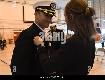 NAS PATUXENT RIVER, Maryland (10. Januar 2024) – Kapitän Douglas Burfield, NAS Patuxent River Commanding Officer, erhält die Anstecknadel des Navy Command an Land von seiner Frau Kathryn bei der Zeremonie zum Wechsel des Kommandos am NAS Patuxent River am 10. Januar. Burfield übernahm das Kommando über die Luftstation von Captain Derrick Kingsley, der nach 27 Jahren Marinedienst in den Ruhestand ging. Stockfoto