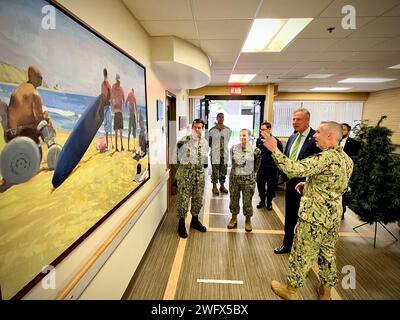 SAN DIEGO, Kalifornien (3. Januar 2024) das Naval Medical Center San Diego (NMCSD) veranstaltete den Kongressabgeordneten Scott Peters (CA-50) für eine Kommandoreise. Captain Robert Sheu (R), Abteilungsleiter Comprehensive Combat and Complex Casualty Care (C-5), liefert Peters (zweiter von R) eine historische Beschreibung der Abteilung durch ein prominentes Gemälde, das frühere C-5-Patienten nach schweren Verletzungen und ihrer anschließenden Genesung zeigt. Die Mission des NMCSD ist es, die Mitglieder des Dienstes auf den Einsatz zur Unterstützung der Einsatzkräfte vorzubereiten, qualitativ hochwertige Gesundheitsdienstleistungen zu erbringen und die Zukunft der Militärmedizin durch zu gestalten Stockfoto