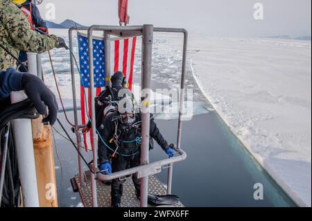 US Coast Guard Petty Officer 1. Klasse Ryan Miller, und Petty Officer 2nd Class Corey Smith, Taucher von Regional Dive locker West bzw. Pacific, werden vom U.S. Coast Guard Cutter Polar Star (WAGB 10) ins Wasser gelassen, bevor sie am 7. Januar 2024 im McMurdo Sound in der Antarktis eintauchen. Jedes Jahr arbeitet ein gemeinsames Team an der erfolgreichen Operation Deep Freeze zusammen. Aktive Mitglieder der U.S. Air Force, Army, Coast Guard und Navy arbeiten zusammen, um eine JTF-SFA zu schmieden, die die Tradition des US-Militärs fortsetzt Stockfoto