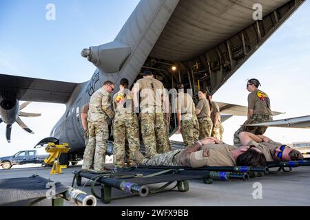 Die US-Luftwaffe und medizinisches Personal der US-Armee bereiten sich darauf vor, einen simulierten Patienten in ein C-130H Hercules-Flugzeug zu laden, das der 75. Expeditionstruppe in Camp Lemonnier, Dschibuti, am 12. Januar 2024 zugeteilt wurde. Die Ausbildungsveranstaltung bot eine Plattform für die verschiedenen militärischen Zweige und medizinischen Berufsfelder, um gemeinsam zu Proben, um Leben zu retten. Stockfoto