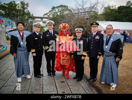 Kapitän Michael Fontaine, Commander, Fleet Activities Sasebo links vom Zentrum, und die japanischen Selbstverteidigungskräfte und die Sasebo Chamber of Commerce and Industry Leader posieren für ein Foto mit einer „Bian Lian“-Tänzerin beim Toka Ebisu Festival am Kameyama Hachimangu Schrein in Sasebo, Japan, 10. Januar 2024. Das Festival findet jedes Jahr am 10. Januar statt, um für Sicherheit und Wohlstand für sich, ihre Familien und Unternehmen im neuen Jahr zu beten. Stockfoto