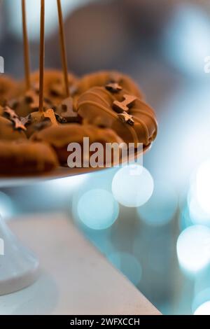 Mini-braune Donuts, Nahaufnahme. Teil der Deko zum 1. Geburtstag. Bokeh, unscharfer Hintergrund. Stockfoto