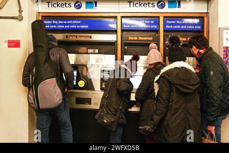 London, Vereinigtes Königreich - 01. Februar 2019: Gruppe unbekannter Passagiere in Winterkleidung, die darauf warten, Tickets für die Untergrundfahrt an einem Austern-geldautomaten zu kaufen Stockfoto