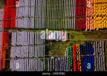 Aus der Vogelperspektive von Menschen, die in einer öffentlichen Wäscherei arbeiten, die zum Trocknen von bunten Stoffen in Narayanganj, Dhaka, Bangladesch hängend sind. Stockfoto