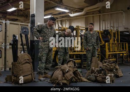 US-Marines mit dem Kommandoelement, 31st Marine Expeditionary Unit, inszenieren Ausrüstung während einer Probe für die erweiterte Basis auf dem amphibischen Angriffsschiff USS America (LHA 6) in der Philippinischen See, 30. Januar 2024. SEABO-Proben ermutigen Marines und Seeleute, Seite an Seite zu arbeiten und ihre Ausrüstungsfähigkeiten und ihr Verständnis der Einsatzfähigkeiten zu verfeinern. Die 31. MEU, die einzige fortlaufend vorgelagerte MEU des Marinekorps, stellt eine flexible und tödliche Truppe bereit, die als führende Krisenreaktionstruppe in der in eine breite Palette militärischer Operationen bereit ist Stockfoto