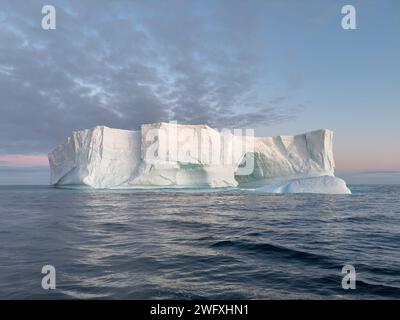 Ein riesiger hoher, abbrechender Gletscher driftet im südlichen Ozean vor der Küste der Antarktis bei Sonnenuntergang, der Antarktischen Halbinsel, dem südlichen Polarkreis Stockfoto