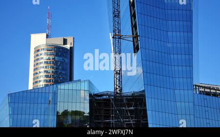 Vilnius (Litauen): Moderne Glashochhäuser im Bau. Ungewöhnlicher Aufnahmewinkel. Klarer Himmel, Reflexionen in den Fenstern Stockfoto