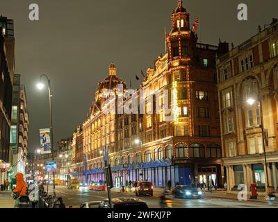 Blick auf das berühmte Luxuskaufhaus Harrods an der Brompton Road in Knightsbridge London bei Nacht beleuchtet Stockfoto