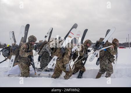 Das Team der Hauptquartier- und Hauptquartierkompanie, 2. Bataillon, 30. Infanterieregiment, 3. Brigade Combat Team, 10. Mountain Division, arbeitet zusammen, um einen Ahkio-Schlitten durch die Landezone der Division Hill während der D-Series XXIV Winter Challenge auf Fort Drum, NY, 19. Januar 2024 zu schleppen. Die D-Serie bezieht sich auf die Kulminationsübung, die die Soldaten der 10. Gebirgsdivision von März bis April 1944 durchmachten, um sich auf den Kampf in den Bergen Italiens vorzubereiten. Stockfoto