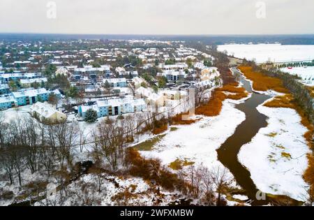 Ländlicher Winter aus der Vogelperspektive des ländlichen Dorfes am Fluss mit Schnee bedeckt Stockfoto