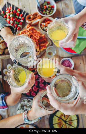 Stoßen Sie mit einem Freund auf der Terrasse an und genießen Sie gemeinsam. Sommer-Aperitif mit Gruppe von Freunden Stockfoto