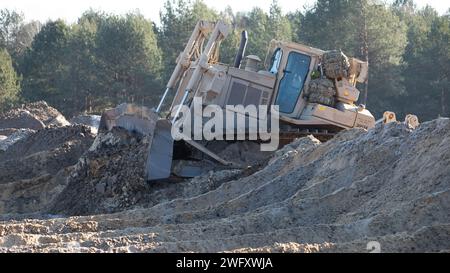 Ein Caterpillar D9 "Bulldozer" der Alpha-Kompanie, 40. Brigade-Ingenieur-Bataillon, das dem 1. Bataillon, 35. Panzerregiment, 2. Panzerbrigade-Kampfteam, 1. Panzerdivision, während des Einsatzes reißt man durch eine Schmutzbarriere, um eine Einstiegslinie für Kampffahrzeuge während einer Joint Combined Arms Live Fire Übung im Nowa Deba Training Area in Polen am 29. Januar 2024 zu schaffen. Neben der Verbesserung der militärischen Fähigkeiten unterstrich diese gemeinsame Übung das Engagement der NATO-Mitgliedsstaaten für die kollektive Verteidigung und die Erhaltung der regionalen Stabilität. Stockfoto