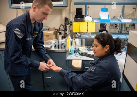 Krankenhauskorpsman 2. Klasse Ryan S. Smith, aus Barberton, Ohio, der Zahnarztabteilung zugeteilt. und die 3rd Class (AW) Diana S. Rodriguezcanchari, aus Brooklyn, New York, die der Intermediate-Maintenance-Abteilung für Flugzeuge zugewiesen wurde, nehmen an einer Massenübung an Bord eines Flugzeugträgers der Nimitz-Klasse USS George Washington (CVN 73) im Atlantik am 20. Januar 2024 Teil. George Washington unterstützt derzeit die Qualifikation von Fluggesellschaften. Stockfoto