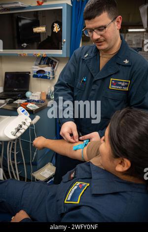 Krankenhaus Korpsman 2. Klasse (FMF) Christopher A. Puglisi, aus San Sebastian, Puerto Rico, der Zahnabteilung zugewiesen, und die 3rd Class (AW) Diana S. Rodriguezcanchari, aus Brooklyn, New York, die der Intermediate-Maintenance-Abteilung für Flugzeuge zugewiesen wurde, nehmen an einer Massenübung an Bord eines Flugzeugträgers der Nimitz-Klasse USS George Washington (CVN 73) im Atlantik am 20. Januar 2024 Teil. George Washington unterstützt derzeit die Qualifikation von Fluggesellschaften. Stockfoto