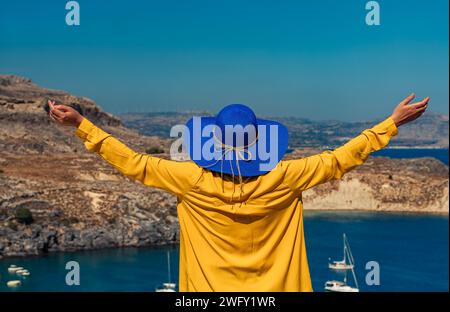 Frau mit weit geöffneten Armen im Urlaub auf dem Meer. Stockfoto