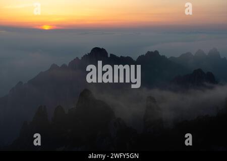 Eine goldene Sonne untergeht über dem Wolkenmeer vom Turtle Peak in den Huangshan Yellow Mountains aus. Stockfoto