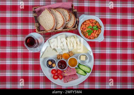 Türkische Küche Frühstücksteller. Weißer Frühstücksteller mit geschnittenen Kirschtomaten, Gurke und gekochtem Ei auf Holztisch. Stockfoto